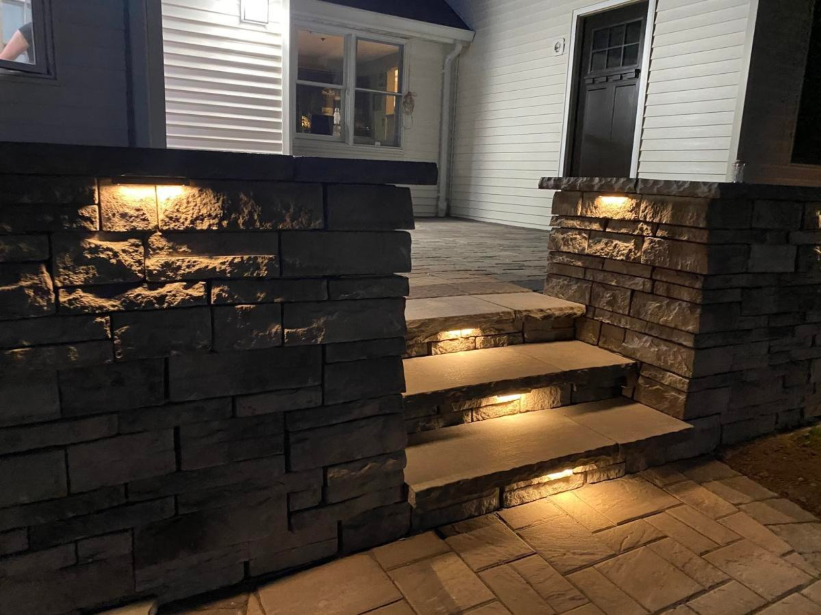 Landscape lighting illuminating stone steps and wall, enhancing safety and beauty of outdoor space in Princeton, NJ.