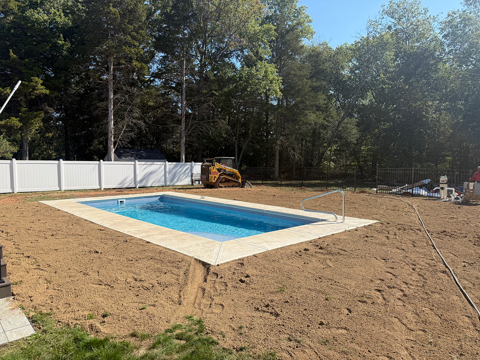 lawn 2 Newly installed swimming pool surrounded by freshly prepared soil, showcasing a clean landscape ready for lawn reseeding and maintenance by Urban Landscapes.